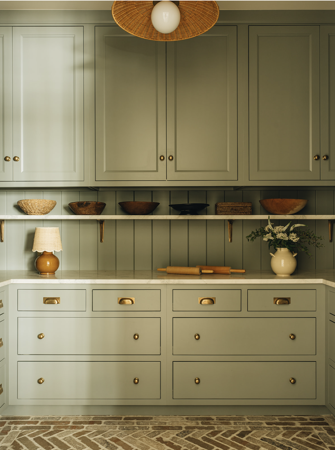 We are in the mood to pare down today, clear the clutter, and we have a feeling that, after seeing this perfectly tailored lake house from Jean Stoffer, you will be too! Kitchen with white clapboard and black and gold lanterns -Stoffer Photography Interiors dining room from Jean Stoffer design with water view - Stoffer Photography Interiors - Jean Stoffer Lake House - butler's pantry in sage green