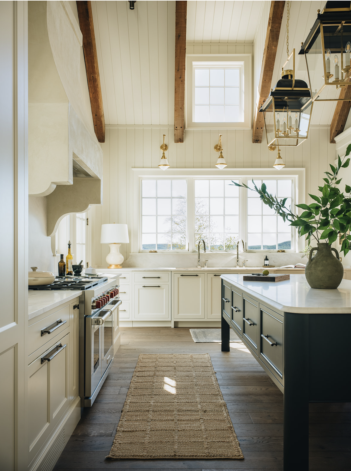 We are in the mood to pare down today, clear the clutter, and we have a feeling that, after seeing this perfectly tailored lake house from Jean Stoffer, you will be too! Kitchen with white clapboard and black and gold lanterns -Stoffer Photography Interiors