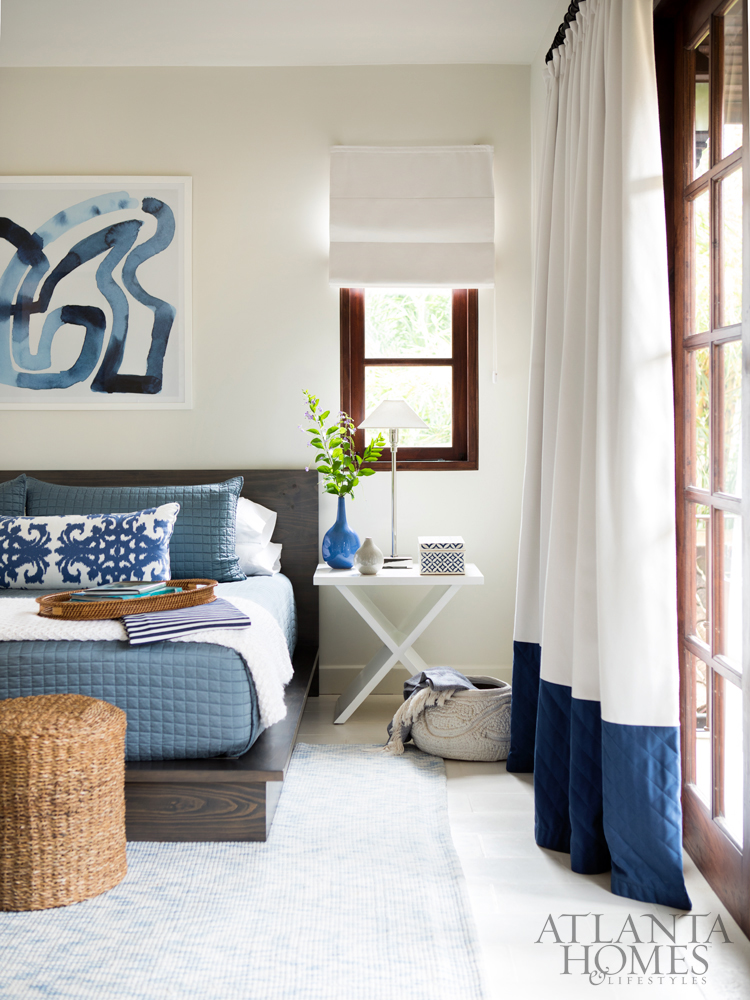 Source: Atlanta Homes & Lifestyles | Interior Design: Beth Webb Design | Photography Erica George Dines - beach house - wicker furniture - beach cottage - beach house style = beach house inspo - Costa Rica - bedroom - blue and white bedroom - abstract art