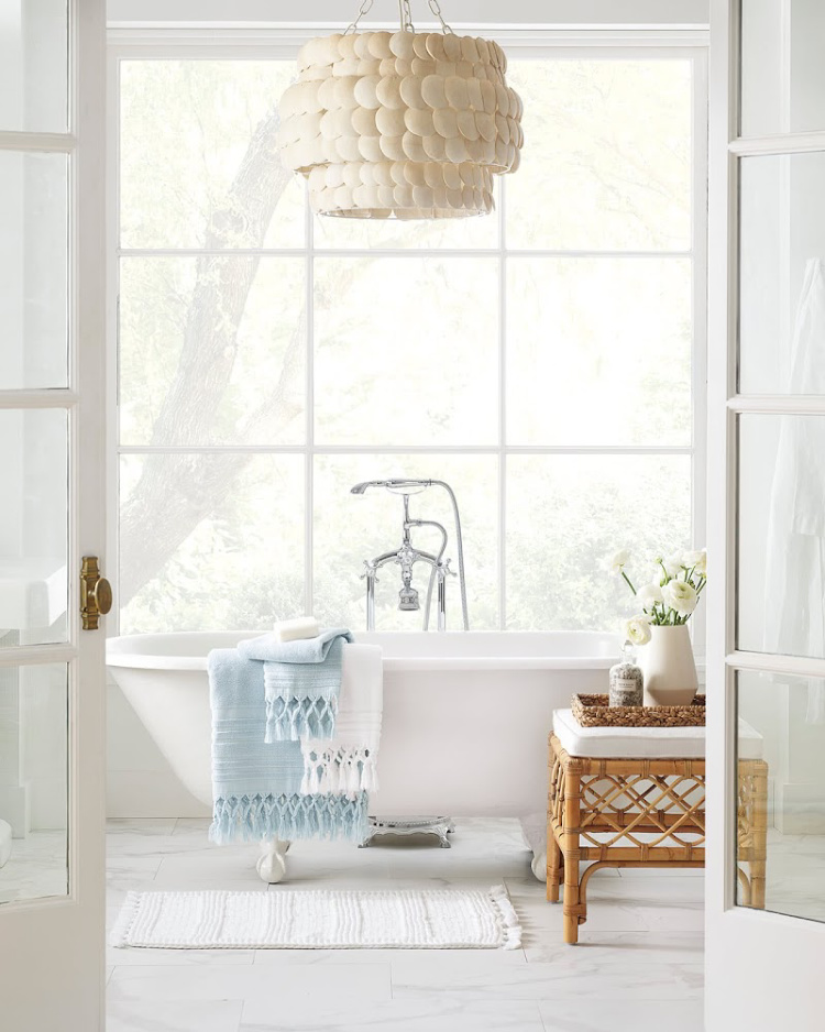 bathroom with coconut shell chandelier and wicker stool from Serena & Lily