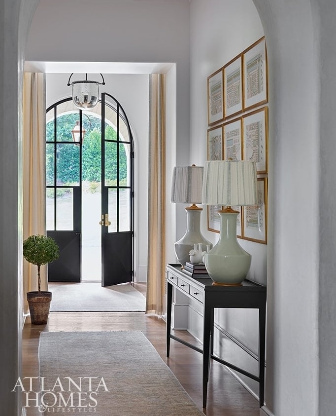Tour a fabulous home in Atlanta with a fresh update designed by @tsadamsstudio with interiors by @laurendeloachinteriors⁠
⁠
Source: Atlanta Homes & Lifestyles @atlantahomesmag⁠
Photography: @emilyfollowillphotographer⁠
Builder:  @macallan.custom.homes⁠
⁠
⁠
#entry #foyer #welcome #steeldoors #arch #gallerywall #designchic #housebeautiful #pairs #pairoflamps #consoletable