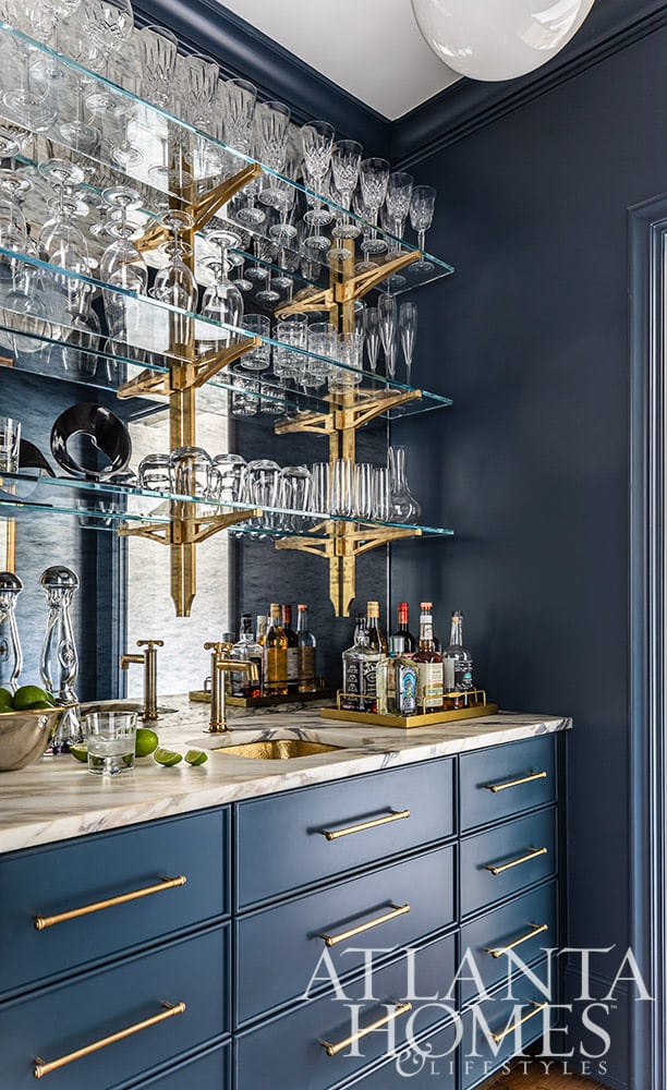 Anna Booth, a talented interior designer, undertook the remarkable task of transforming a 1940s Buckhead home into a captivating contemporary French-inspired residence. moody blue, bar, wet bar, brass, brass and glass, brass sink Source: Atlanta Homes & Lifestyles Interior Design Anna Booth Interiors Landscape Architect:  Bill Caldwell, BCLA Design Builder: Paces Builder Group Photography: Jeff Herr