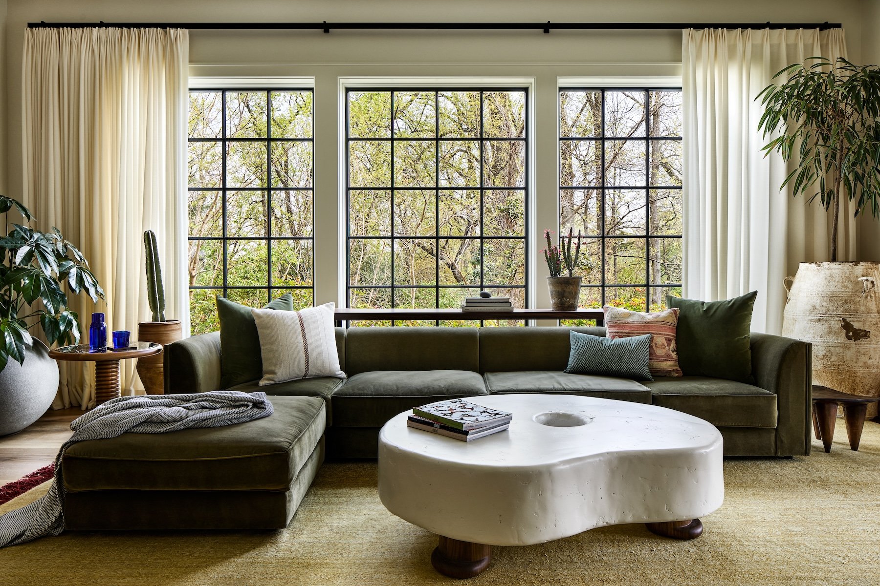 Zoe Feldman | Stacy Zarin Goldberg Photography - Beautiful windows are the perfect backdrop to this stunning living room with a sction sofa and curved coffee table