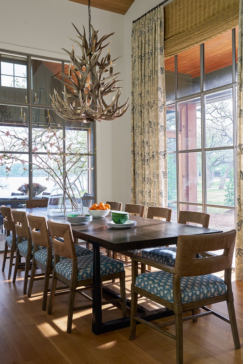 With her brilliant use of layering in interior design, Mary Beth Wagner created a chic and charming Texas hunting cabin. Take a peek! Nathan Schroder Photography - love this dining room with the antler chandelier!