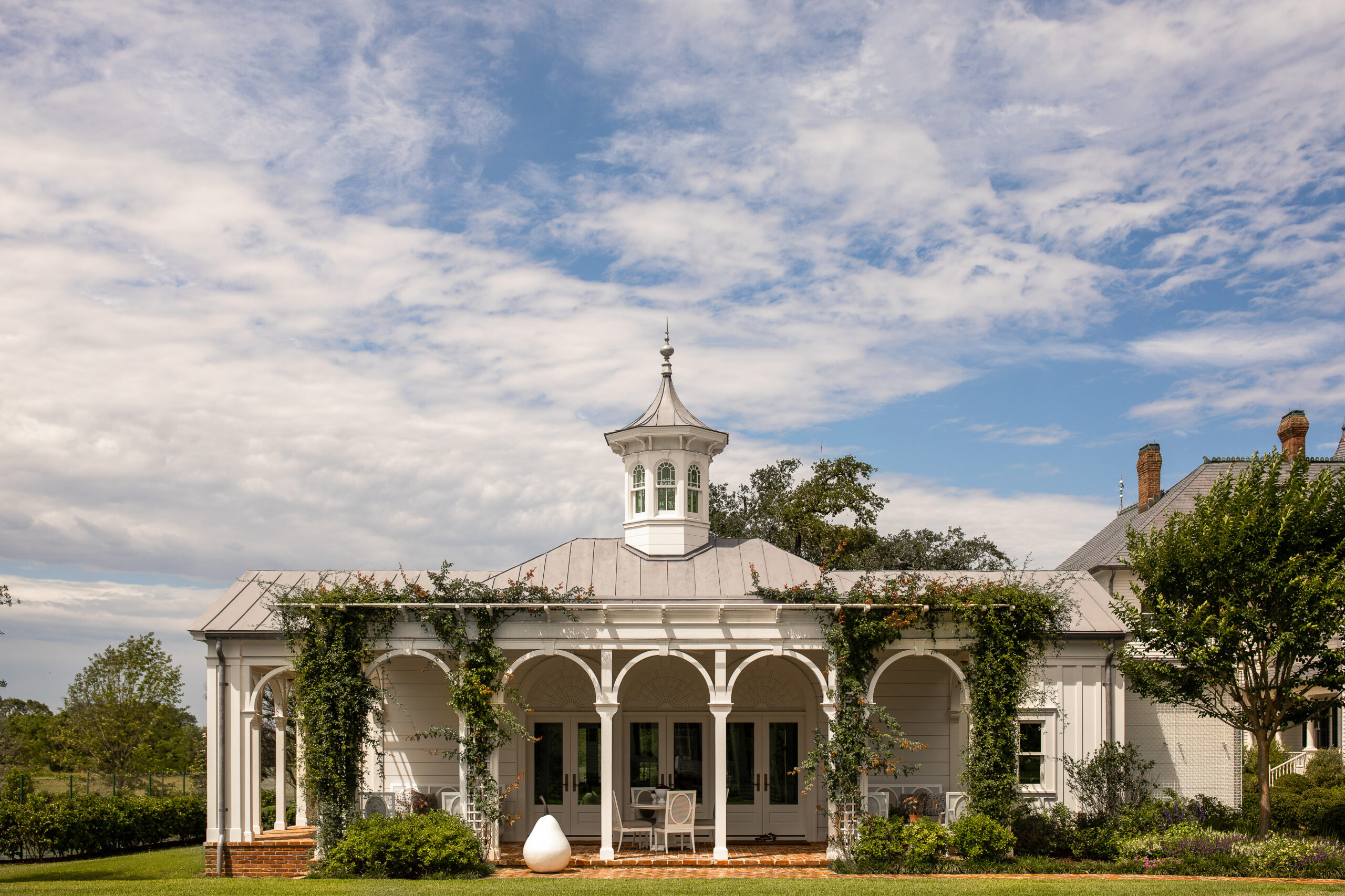 When it comes to inspired architecture, Curtis and Windham  is in a class all their own. Love the traditional interior design ideas of this garden structure with arches forming the covered porch and the amazing cupola