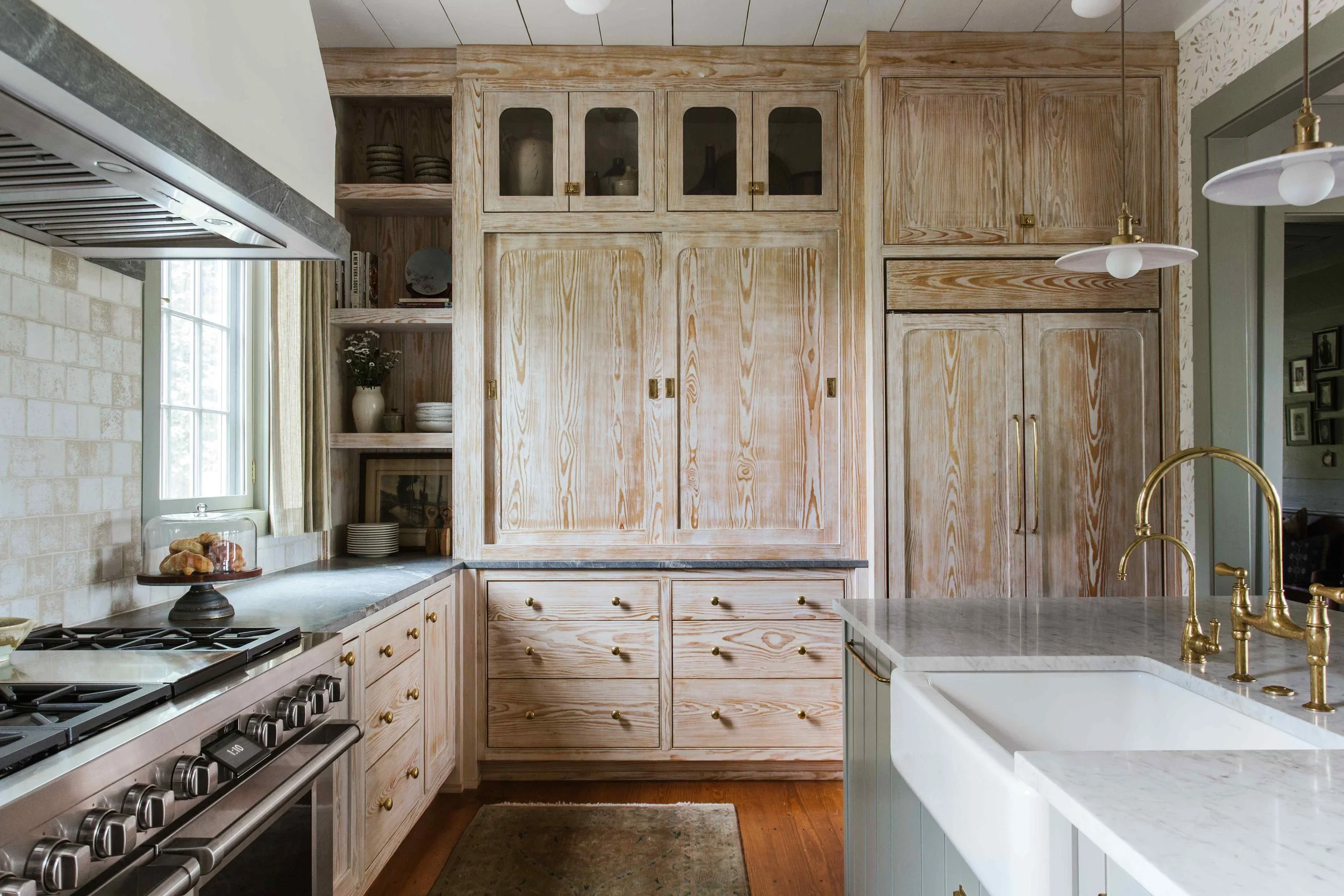 Perfectly proportioned, wholly welcoming and full of Southern charm, this beautiful farmhouse designed by The Misfit House and photographed by the amazing Kristin Karch Photography  is totally making our day.  Take a peek, and we think you’ll understand why! Love the four chair seating area in the living room with the shiplap ceiling - kitchen with bionde wood cabinets and brass hardware