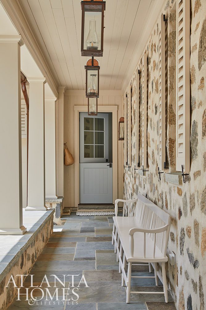 As summer comes to an end, we hope you can steal away for a moment to take a peek at this gorgeous Lake Norman home so beautifully photographed by Emily Followill and chicly styled by Eleanor Roper.  It’s a peaceful, calming home–with incredible views–that just might lend you a moment of serenity.  Jacquelynne P. Lanham Designs created a space that truly feels like a zen retreat, the perfect place to start a stress-free fall! Beautiful covered front porch with stone exterior and flagstone Source: Atlanta Homes & Lifestyles Interior Designer: Jackye Lanham, Jacquelynne P. Lanham Designs  Architect: John D. Haley, John D. Haley  Builder: Scott McMillan, Kingswood Custom Homes, Inc. Landscape Architect: John Howard, Howard Design Studio