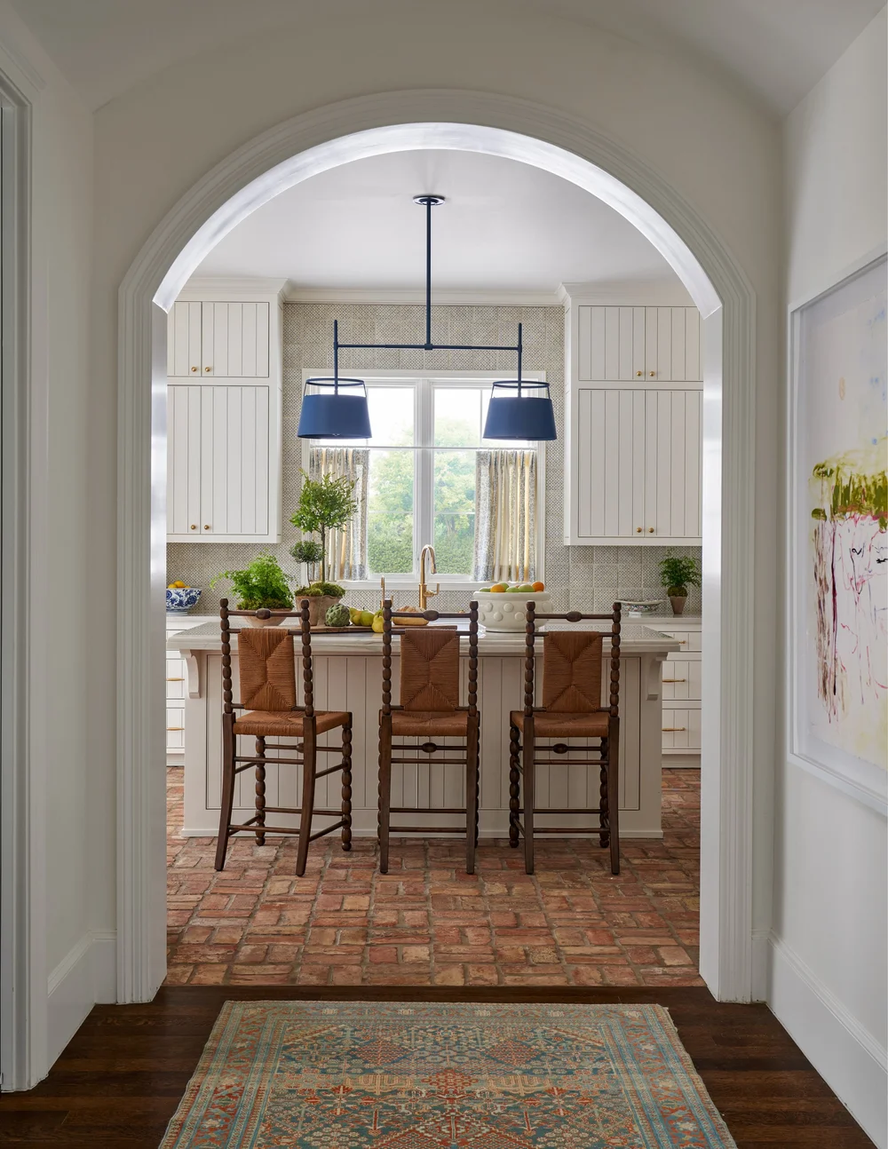 Take a look at 9 beautiful kitchens designed by Jenkins Interiors, each with its unique interpretation of warmth, functionality, and enduring style. Nathan Schroder PHotography - red brick floor with warm white kitchen