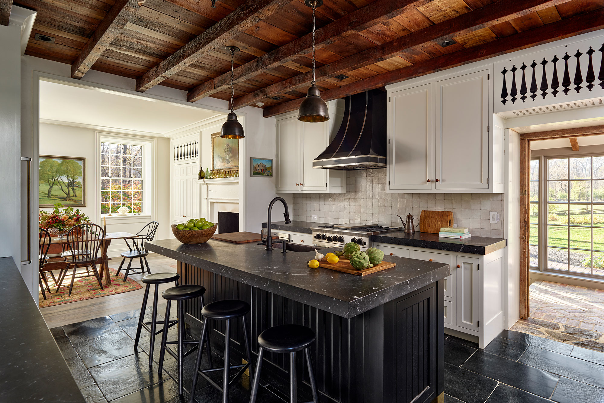 Architectural details of a home from Archer & Buchanan- wood beam ceiling in kitchen with black soapstone island -Builder: Griffiths Construction, Inc. | Photography: Jeffrey Totaro