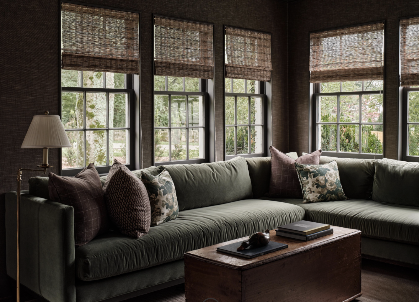 There was a time when open floor plans felt like the ultimate luxury. But lately, we have noticed a shift to rooms with a purpose. Love a sitting room with a green velvet sectional sofa and the texture of the bamboo shades - Sabbe Interior design | Joseph Bradshaw Photography