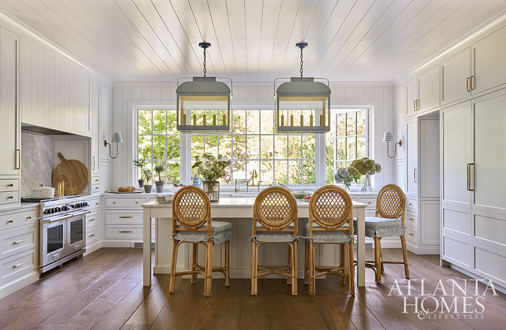 The era of the mountain home of yesterday is over, and today's modern mountain retreat is warm, effortless, and quietly elegant. white paneled walls in the kitchen with beautiful lantern over the island SOURCE; Atlanta Homes & Lifestyles INTERIOR DESIGN  Virginia Nocharli Design  ARCHITECT: Greg Busch Architects BUILDER Rhett Bonner, Bonner Buchanan  LANDSCAPE ARCHITECT  Richard Anderson Landscape Architect