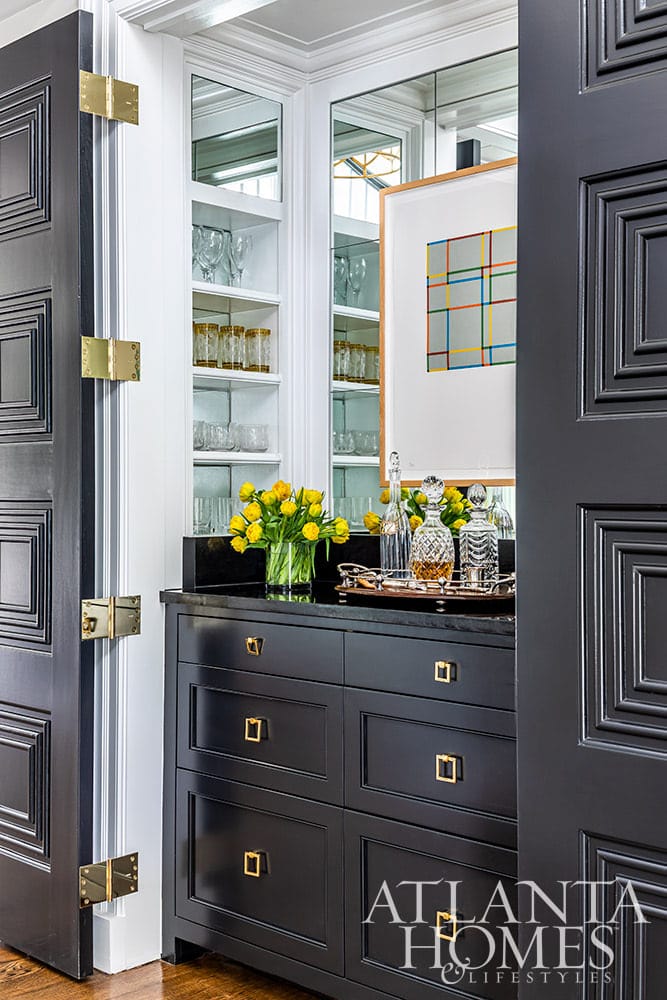 We don’t know about you, but we always love a good house tour.  To that end, Architect Norman Askins and Designer Chris Holt of Holt Interiors absolutely deliver. We are loving the sleek color palettes and sophisticated vibe of this stunning home–with pops of color in all the right places and the perfect dash of metallic chic. Beautiful bar in dark charcoal gray