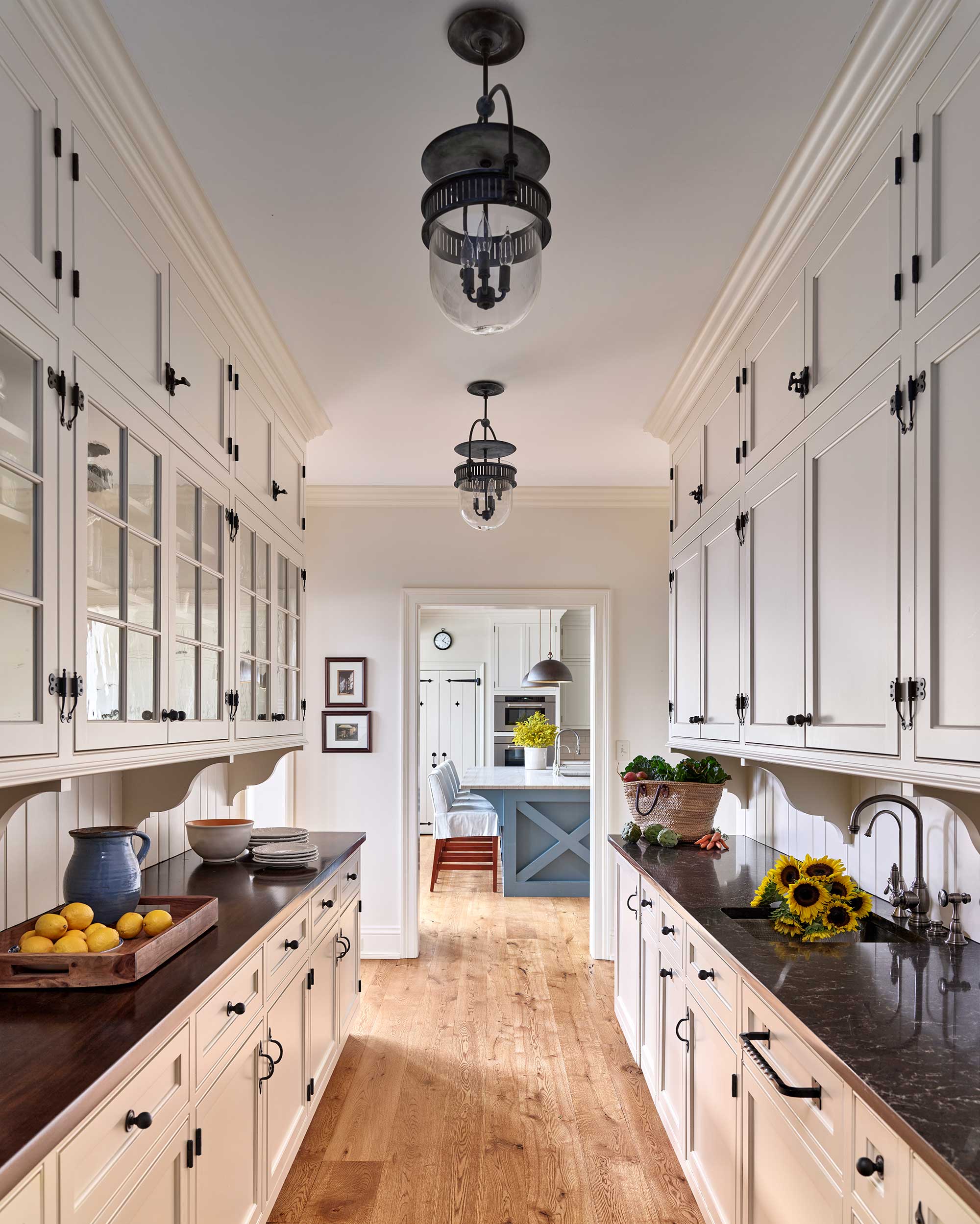 We’d say this home, designed by Archer & Buchanan Architects, hits all the high notes of style. Builder: Cushing Custom Homes, Inc. Beautiful farmhouse kitchen in white with black iron pulls and knobs Landscape Architecture: Jonathan Alderson Landscape Architects Interiors: Barbara Gisel Design Photography: Jeffrey Totaro