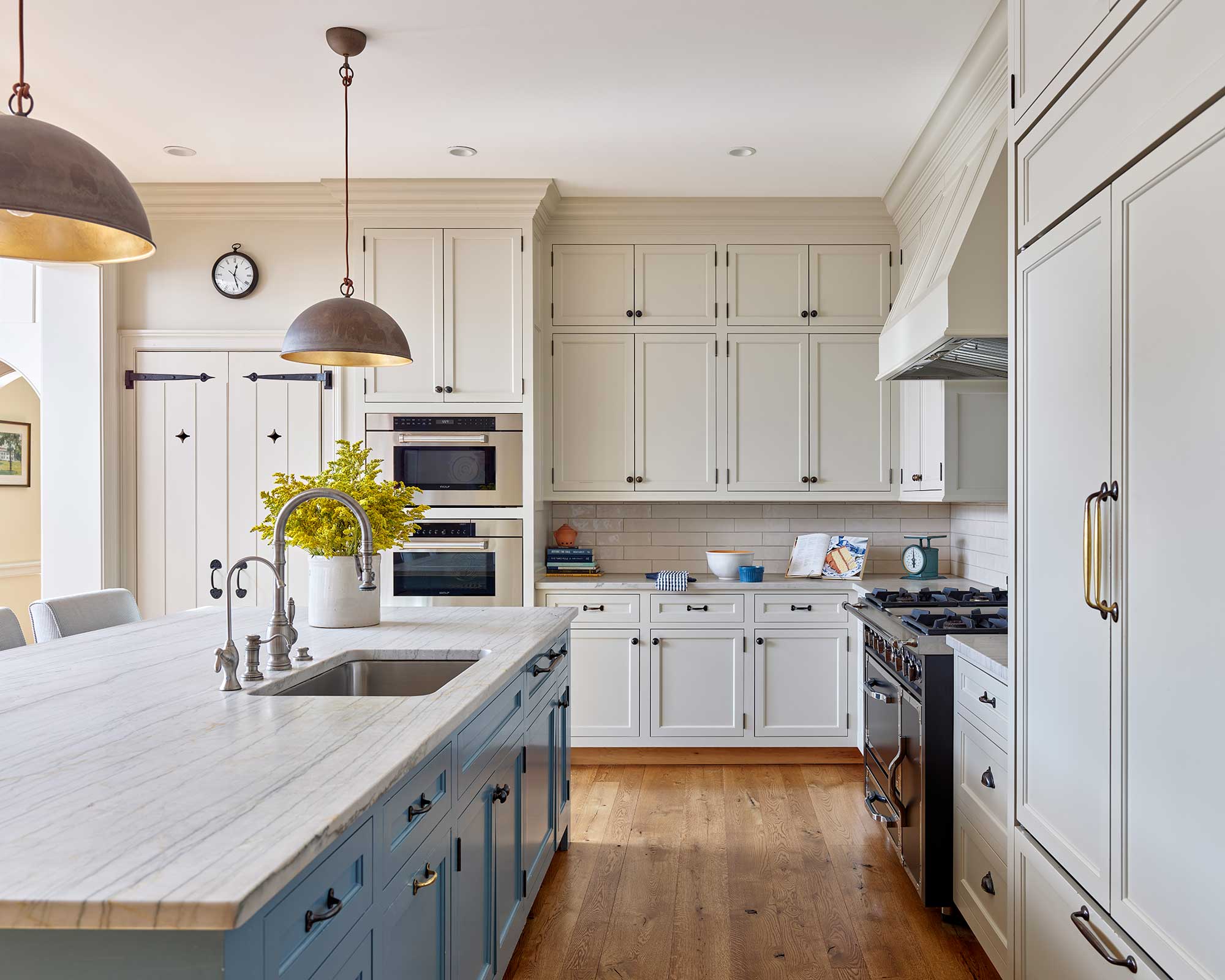We’d say this home, designed by Archer & Buchanan Architects, hits all the high notes of style. Builder: Cushing Custom Homes, Inc. Beautiful farmhouse kitchen in white with black iron pulls and knobs