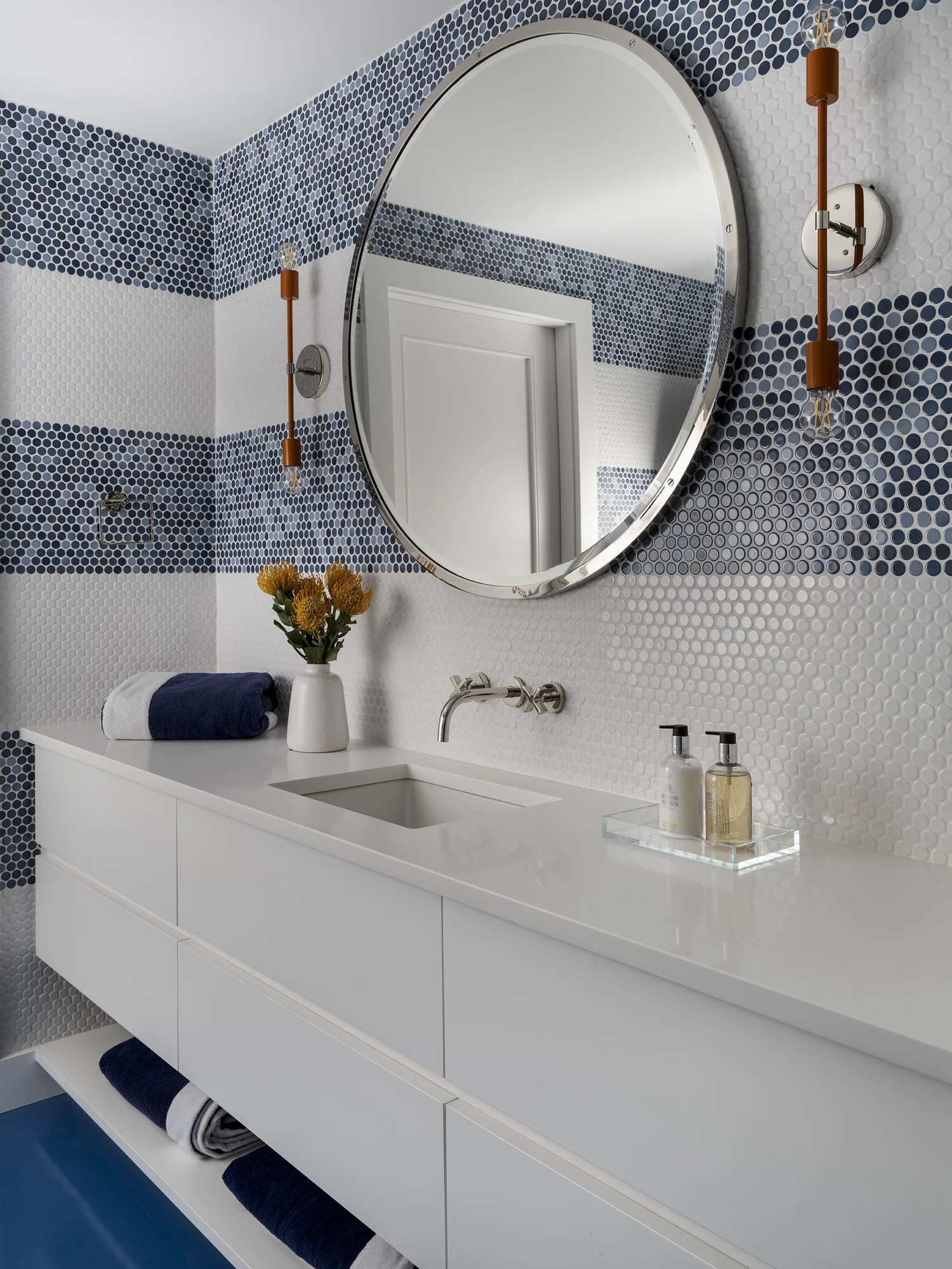 We hope you are having a great week–and are in the mood for touring a stunning home designed by the talented Honey Collins Interiors and beautifully photographed by Alison Gootee Photography.  Neutral enough to be calm, textured enough to be interesting, and layered into complete coziness, this is the perfect home for friends and family.  Whatever your design goals, you’ll find the inspiration to get your home makeover started on the right foot! bathroom with round mirror and blue and with tile