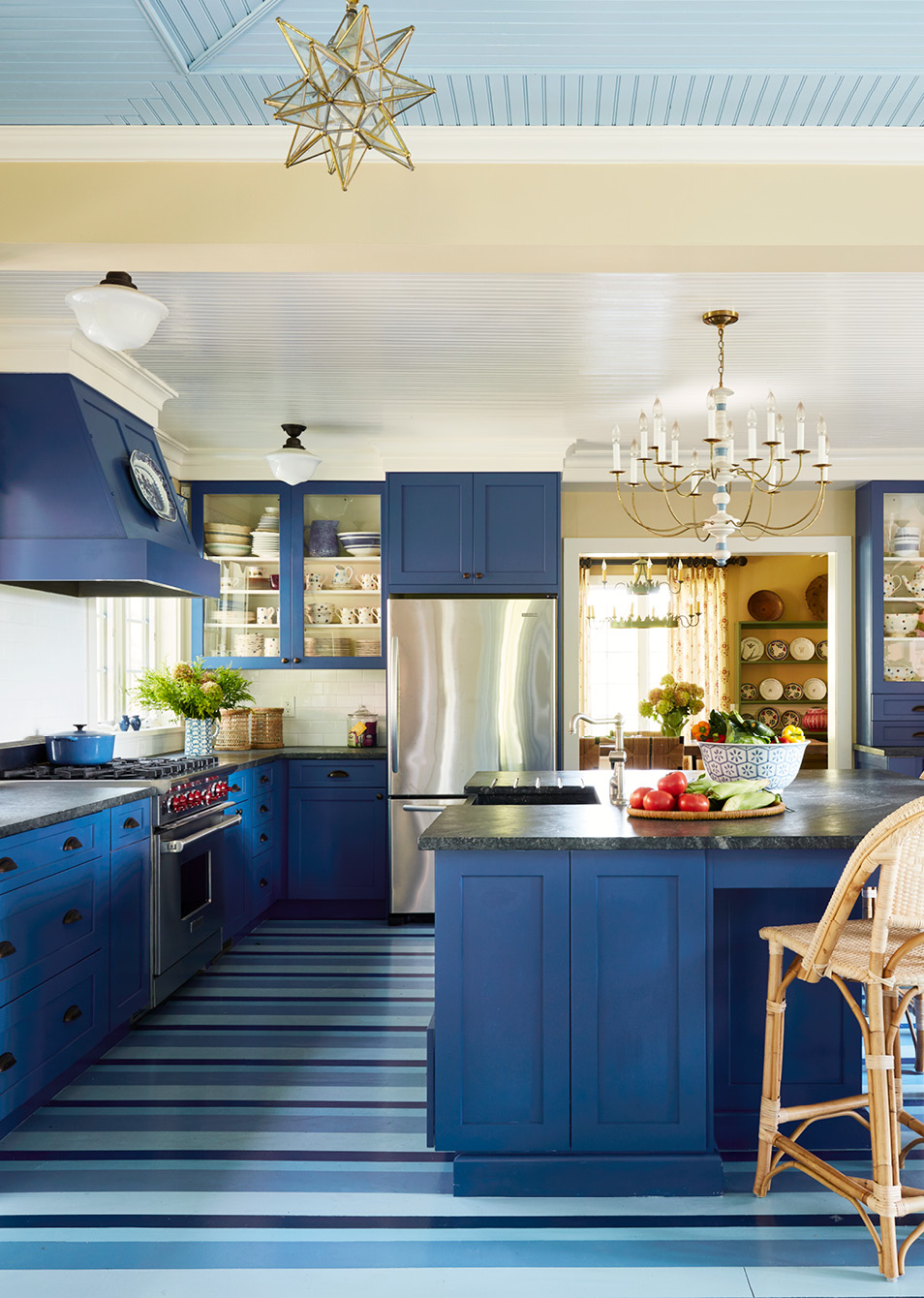 If so, you’re in for a treat today. Todays historic Catskill cottage tour designed by the talented team at Amanda Reynal Interiors is a refuge from the fast pace of modern life.   Charming and livable with lush surroundings and even lusher interiors, this home will make you feel a world away without ever leaving your living room. Thomas Loof Photography - blue kitchen with painted stripes on kitchen floor