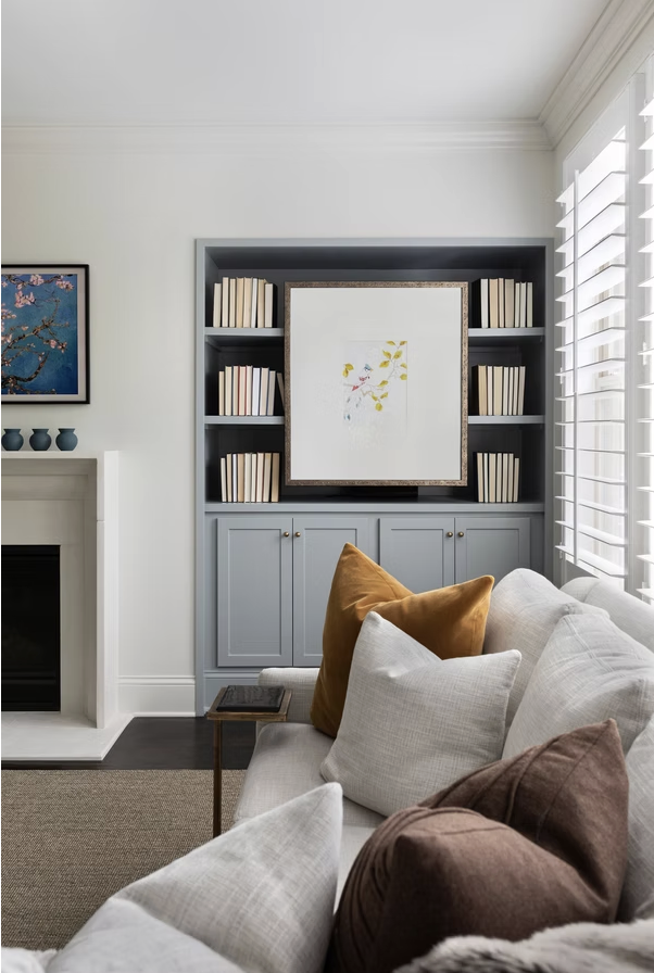 Chic, clean interior design ideas with just the right amount of personality are hallmarks of this talented designer’s style. Take a break, take a peek, and let us know which space of Cerminara Designs is your favorite! stylish living room with blue bookcase and picture hanging over the shelves -Photo: @carolinesharpnack