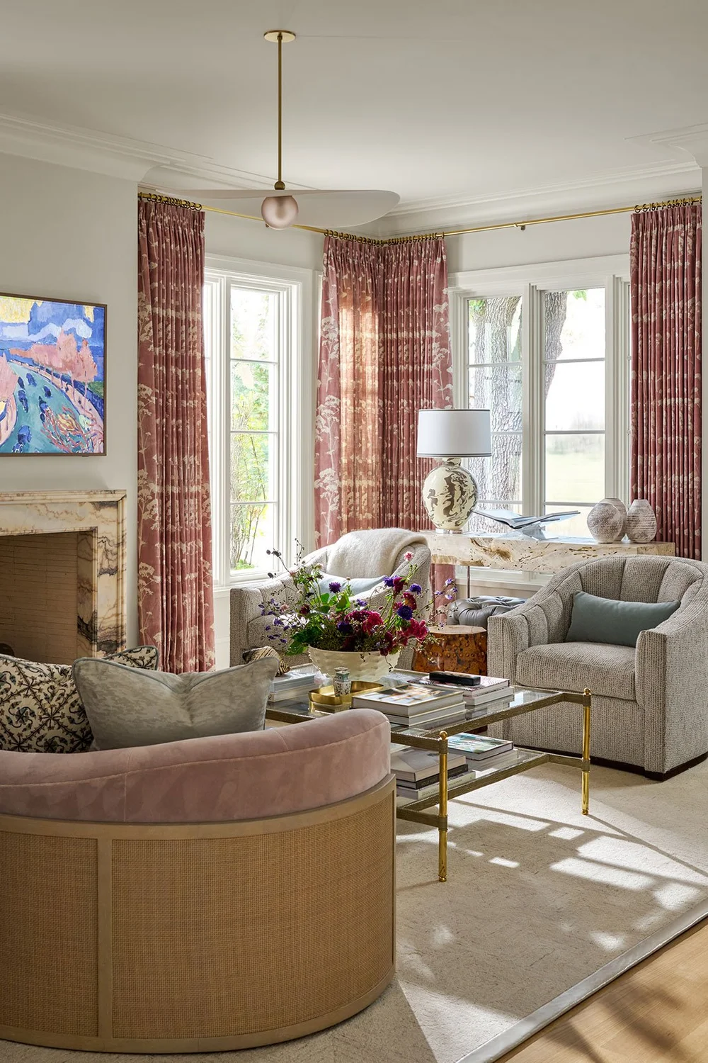 In a world full of minimalism and clean lines, traditional design is making a quiet comeback. It’s the perfect mix of classic touches and updated details, well-suited for family living and entertaining. Where stunning moldings and architectural details live comfortably with more casual room. Mary Beth Wagner Interior Design - Nathan Schroder Photography - Beautiful casual living room with brass and glass coffee table and pair of chairs