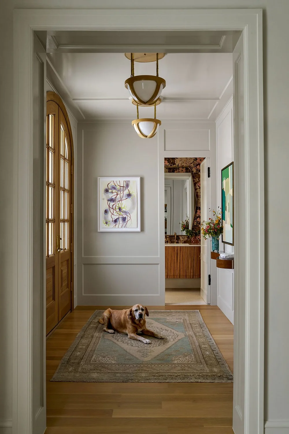 In a world full of minimalism and clean lines, traditional design is making a quiet comeback. It’s the perfect mix of classic touches and updated details, well-suited for family living and entertaining. Where stunning moldings and architectural details live comfortably with more casual room. Mary Beth Wagner Interior Design - Nathan Schroder Photography - Love the arched doorway in this foyer with modern art and applied molding