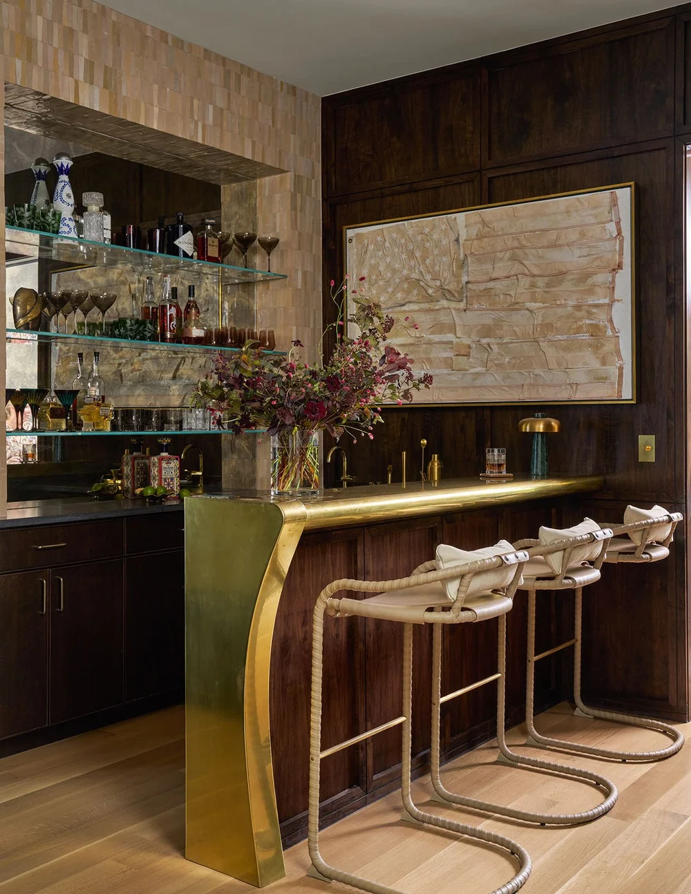 In a world full of minimalism and clean lines, traditional design is making a quiet comeback. It’s the perfect mix of classic touches and updated details, well-suited for family living and entertaining. Where stunning moldings and architectural details live comfortably with more casual room. Mary Beth Wagner Interior Design - Nathan Schroder Photography - gorgeous home bar with glass shelves and roped stools - brass bar