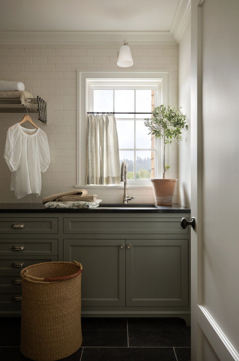 Beauty, sophistication, and attention to detail are just a few of the things that come to mind when we think of Marianne Simon Interiors' beautiful designs. It’s those little things that we think make Simon’s work shine the very most. Laundry room with moody blue cabinets