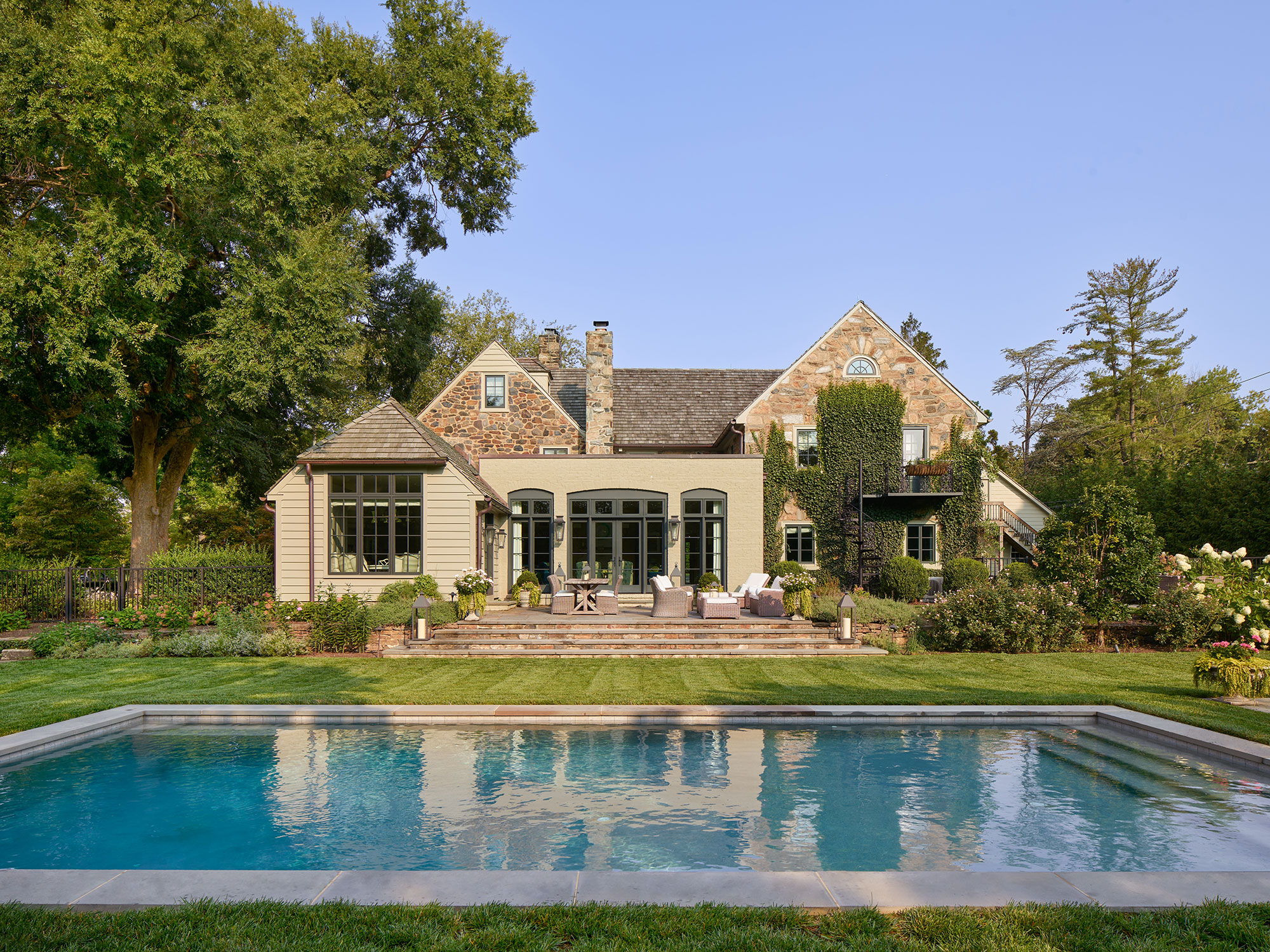 Archer & Buchanan Architects | Halkin | Mason Photography -Beautiful landscaping in the back of this stone house with a pool