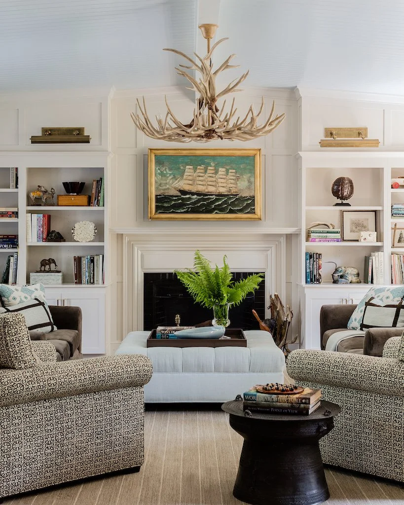 Take a look at a few beautiful spaces that become experiences making us want to linger just a little longer. Honey Collins Interiors | Michael J. Lee Photography Beautiful architecture in this living room with brass library lights over the bookcases and 4 chairs