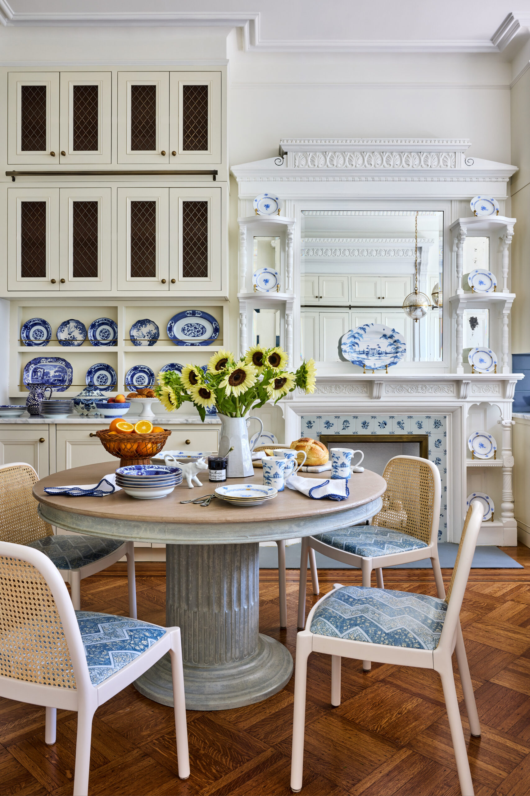 Few things are quite as fun as stepping through the front door of someone else's home, and this beautiful Brooklyn townhouse designed by Jennifer Hunter Design is no exception. Such a a charming breakfast room with blue and white china and round dining table with cane back chairs -Jennifer Hunter Design | Kristen Francis Photography | Frances Bailey Styling