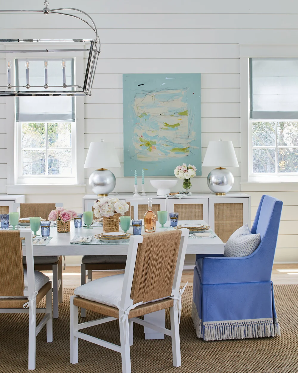 Utterly charming Kara Miller-designed beach house, photographed by , Laurey W. Glenn and styled by Lindsey Ellis Beatty, it feels fresh and inviting. The various color tones, natural materials, and textured accents ground each space, creating a livable home with plenty of style. Love the abstract art on the shiplap wall in this dining room