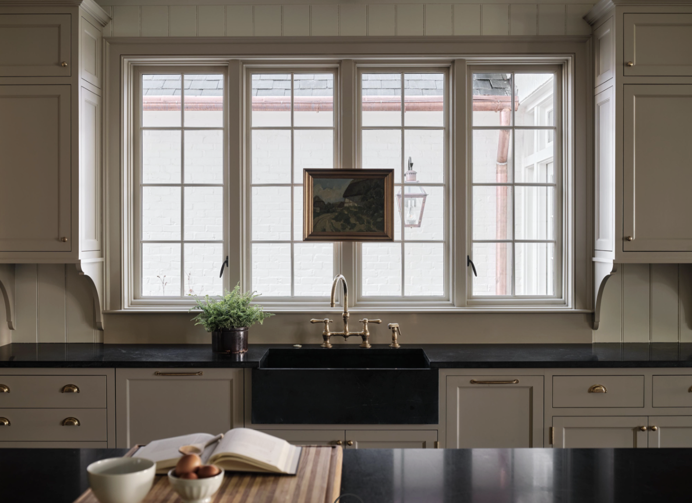 Check out this gorgeous home designed by one of our favorites, Sabbe Interior Design. with beautiful photography by Joseph Bradshaw. Charming kitchen with farmhouse sink and soapstone countertops - love the picture hanging on the window