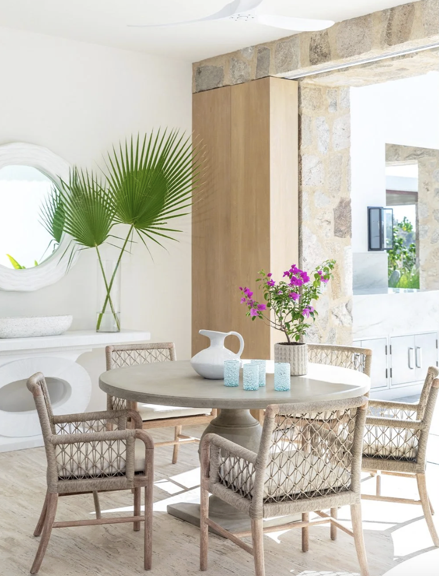 That’s the enchanting essence permeating every corner of this stunning Cabo vacation home designed by A. Wooten Interiors.   Photography: Heidi Harris - love the dining room with a round table and wicker chairs