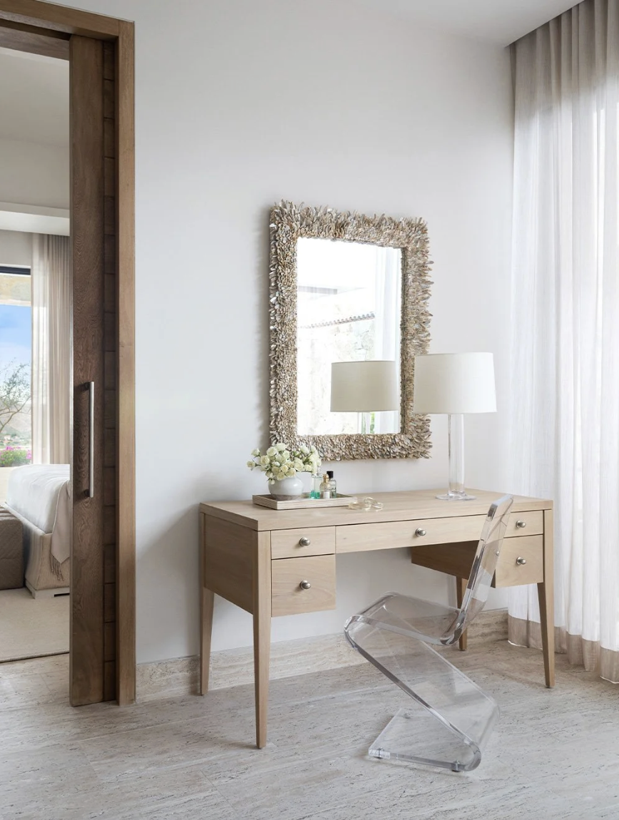That’s the enchanting essence permeating every corner of this stunning Cabo vacation home designed by A. Wooten Interiors.   Photography: Heidi Harris blonde wood desk and shell mirror perfect spot for a vanity or home office