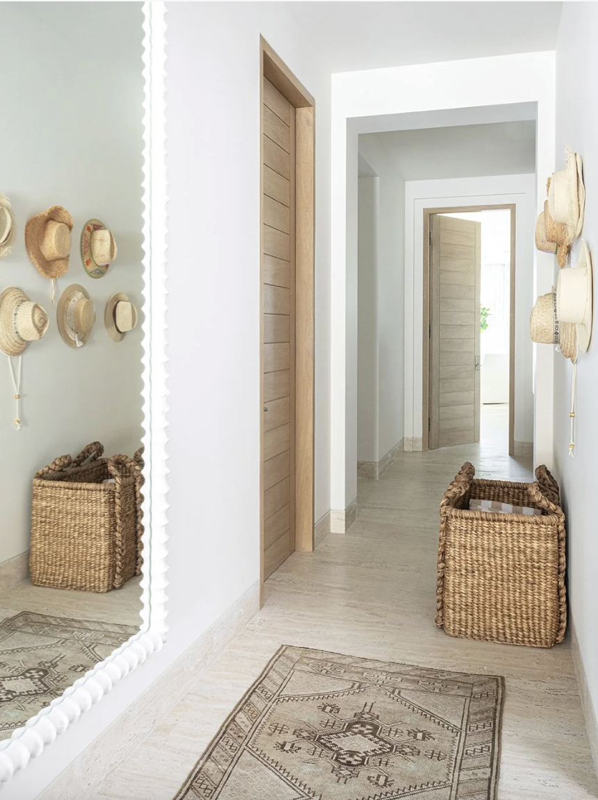 That’s the enchanting essence permeating every corner of this stunning Cabo vacation home designed by A. Wooten Interiors.   Photography: Heidi Harris - Love the hat display hanging in the hallway