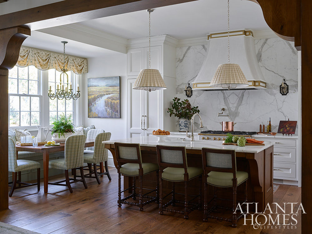You’re going to love today’s post on the one-of-a-kind home designed by Nancy Izlar.  Known for her livable yet elegant aesthetic, Izlar seamlessly marries the best of both family heirlooms and traditional design elements for a collected style. Every corner of this perfectly styled home in Buckhead has been thoughtfully designed to maximize the breathtaking natural surroundings. With the large windows that let in plenty of natural light, this home combines beauty and comfort. Take a look at this timeless home tour, and we think you'll agree! Source: Atlanta Homes & Lifestyles | Interior Design: Nancy Izlar Interiors | Architect: Caroline Rolader, REU Architects | Builder: Wright Marshall and Greg DeLoach, Revival Construction | Landscape Architect: Land Plus | Photographed by Emily Followill | Styled by Holly Bryan and Erin Haraway - white kitchen with 2 pendant lights over the island