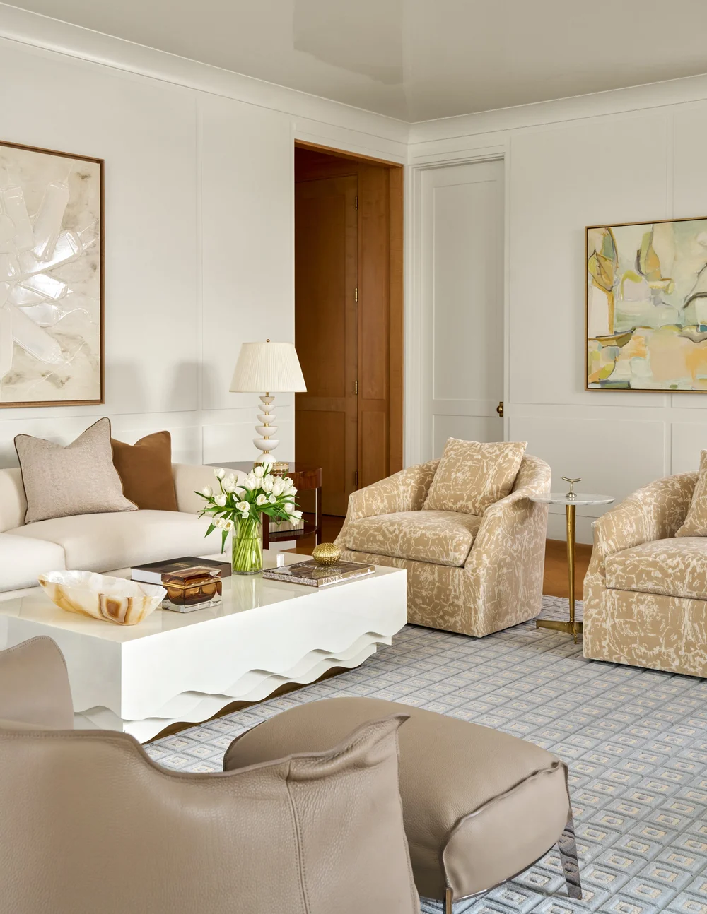 With the right texture, stones, statement lighting, and fabrics, a serene room takes shape. Take a look at warm neutral living room ideas that remain timeless. From layered textures to statement lighting, these designs never go out of style! Mary Beth Wagner Interiors | Nathan Schroder Photography - love the patter in the club chairs and the white scalloped coffee table