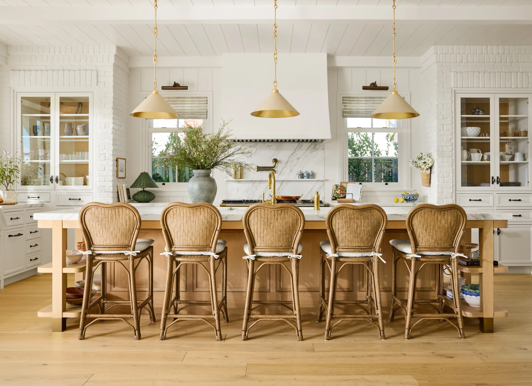 Love the woven kitchen stools and neutral pendants lights add character in this kitchen
