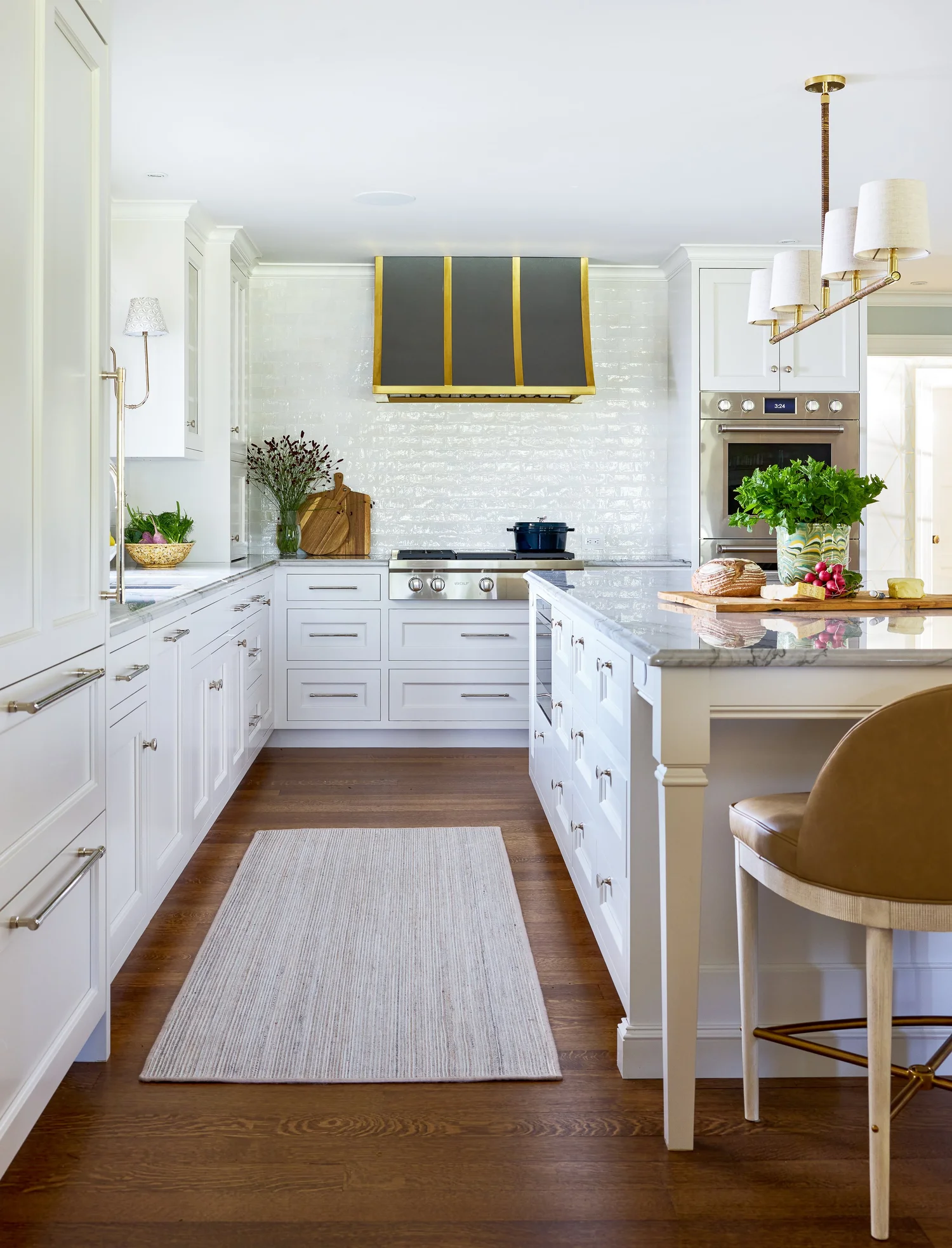 Chic, inviting interiors with just the right amount of personality are hallmarks of this talented designer’s style. Take a break, and take a peek at this beautiful Manchester-by-the-Sea home designed by Honey Collins Interiors. white kitchen design with black range hood for interior design ideas