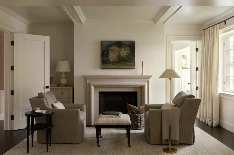one-of-a-kind place in Lake Washington, designed by the talented Marianne Simon Interior Design, beautifully photographed by Aimee Mazzenga, and styled by Cate Ragan Stylist. sitting room in primary bedroom with neutral interiors and a floor lamp and beautiful beams