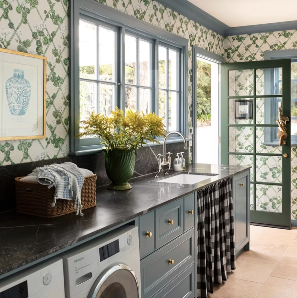 The most charming laundry room - love the moody blue with the green and white wallpaper - Maine House Design | Photography:  Martina Gemmola = Warm, inviting and completely livable…what could be better? From the stunning color palette to the well-placed accessories, every element is perfection. Take a peek at these beautiful interior design ideas, and we think you’ll agree! 
