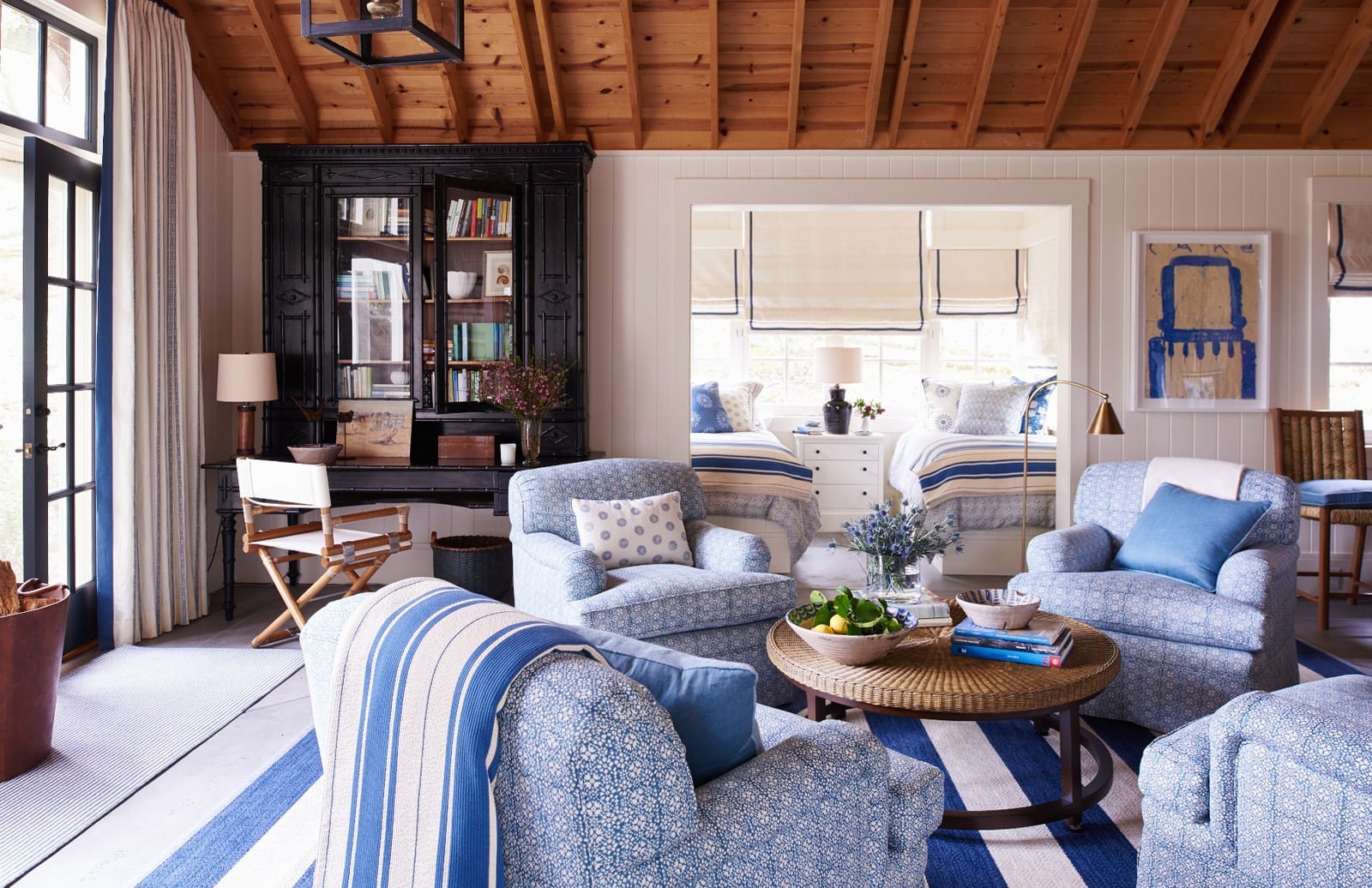 Charming guest house with blue and white patterned fabrics, blue and white art and a blue and white stripe rug