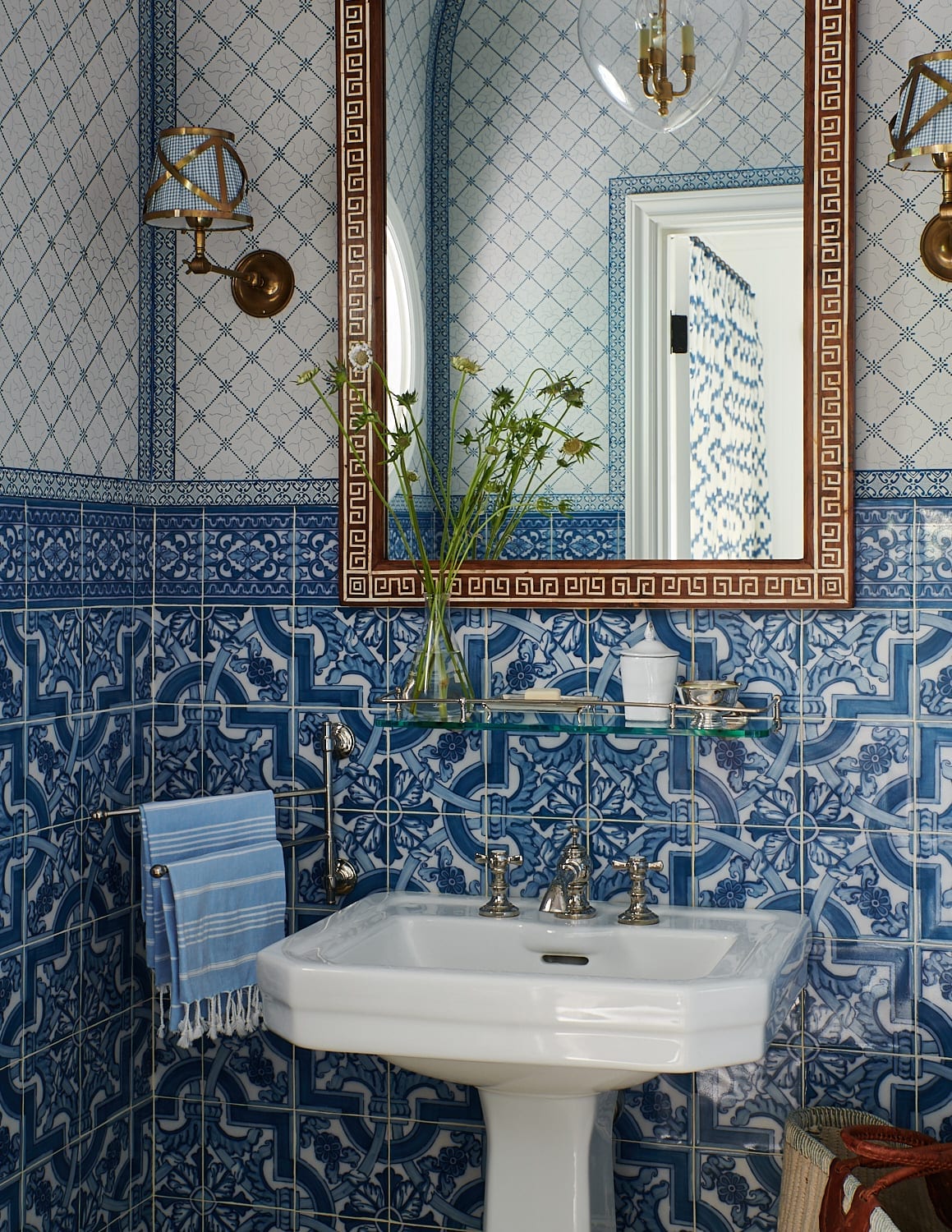 Bathroom featuring blue and white tile walls, classic fixtures, and timeless design details