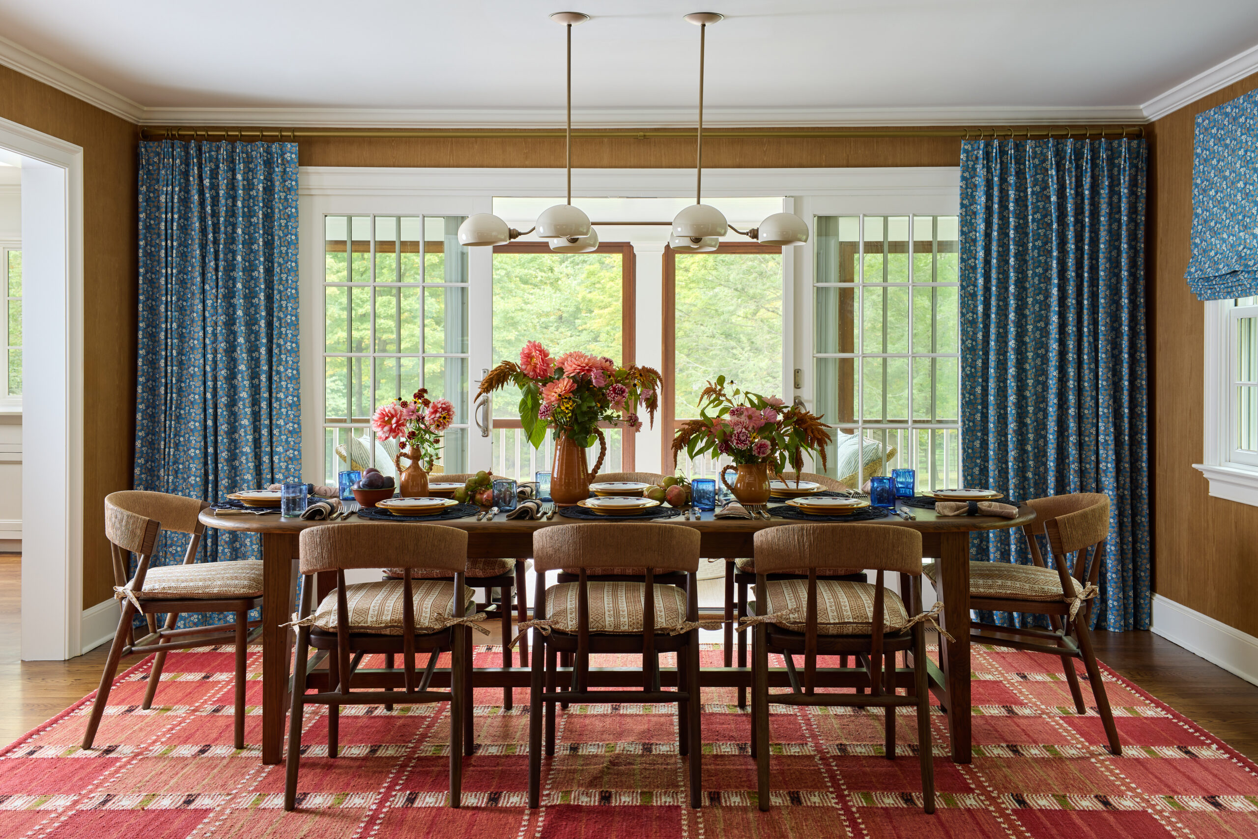 Jennifer Hunter creates perfect spaces in this timeless Bedford home and has us teeming with inspiration. Charming dining room with a red carpet that adds a punch of color