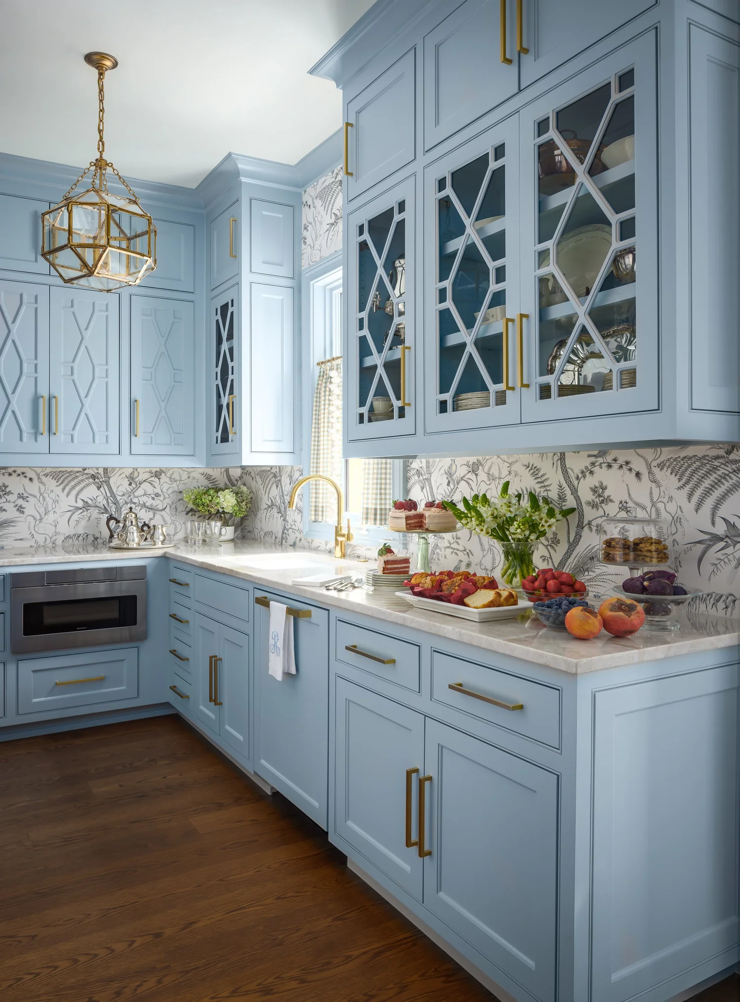 Beautiful blue kitchen with glass front shelves and a timeless home design
