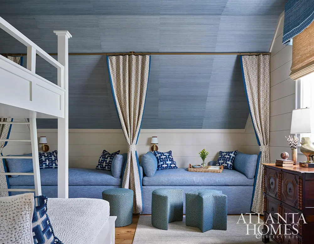 In the spirit of that, this fabulous mountain retreat is the perfect place to spend a summer day–and a great place to curl up by the fire come fall. Blue grasscloth on the walls of the bunk room with curtains seperating the beds