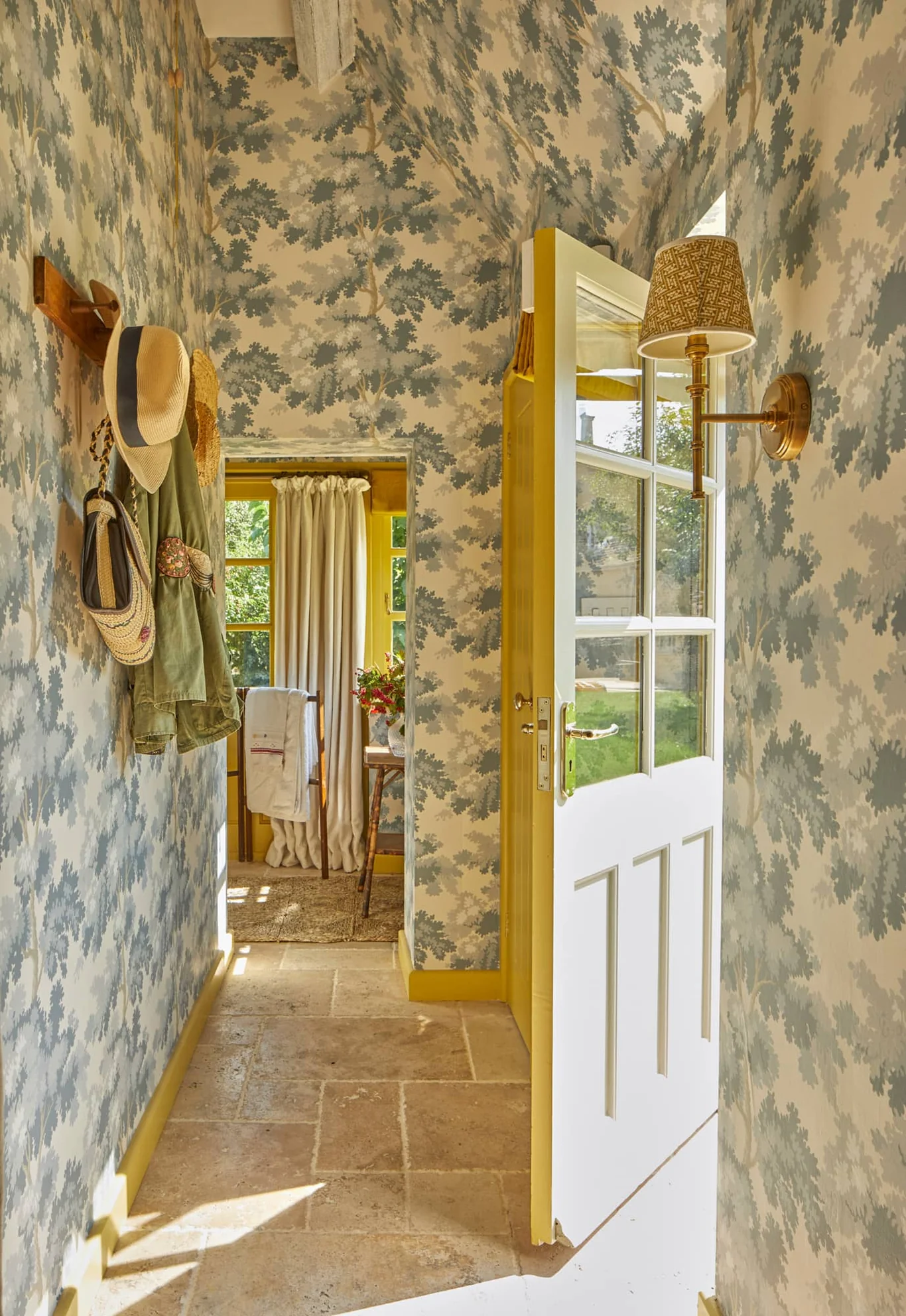 Charming wallpaper in the foyer of a cozy Cotswold cottage with a hat rack