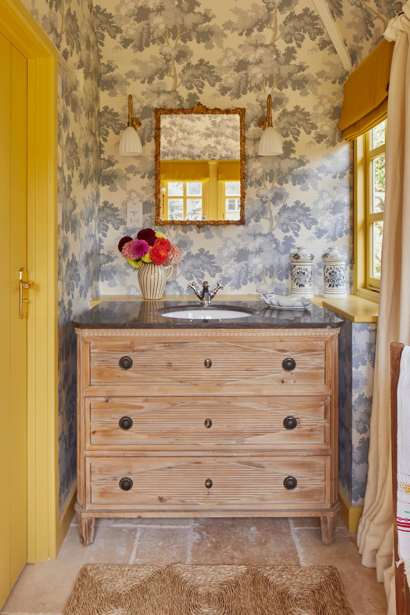 Charming wallpaper in this cozy English cottage bathroom