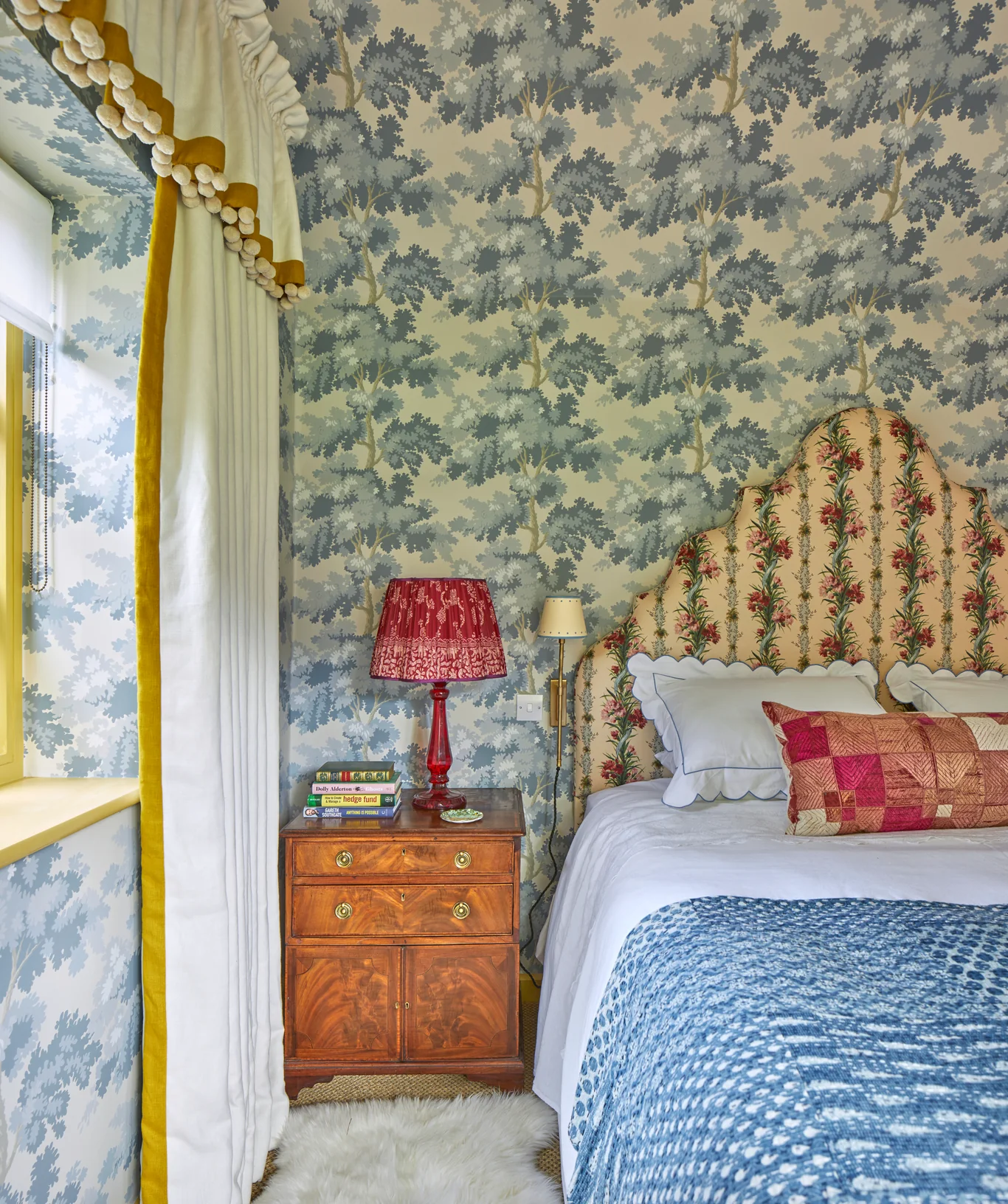 Charming bedroom with a mix of patterns in the wallpaper and headboard