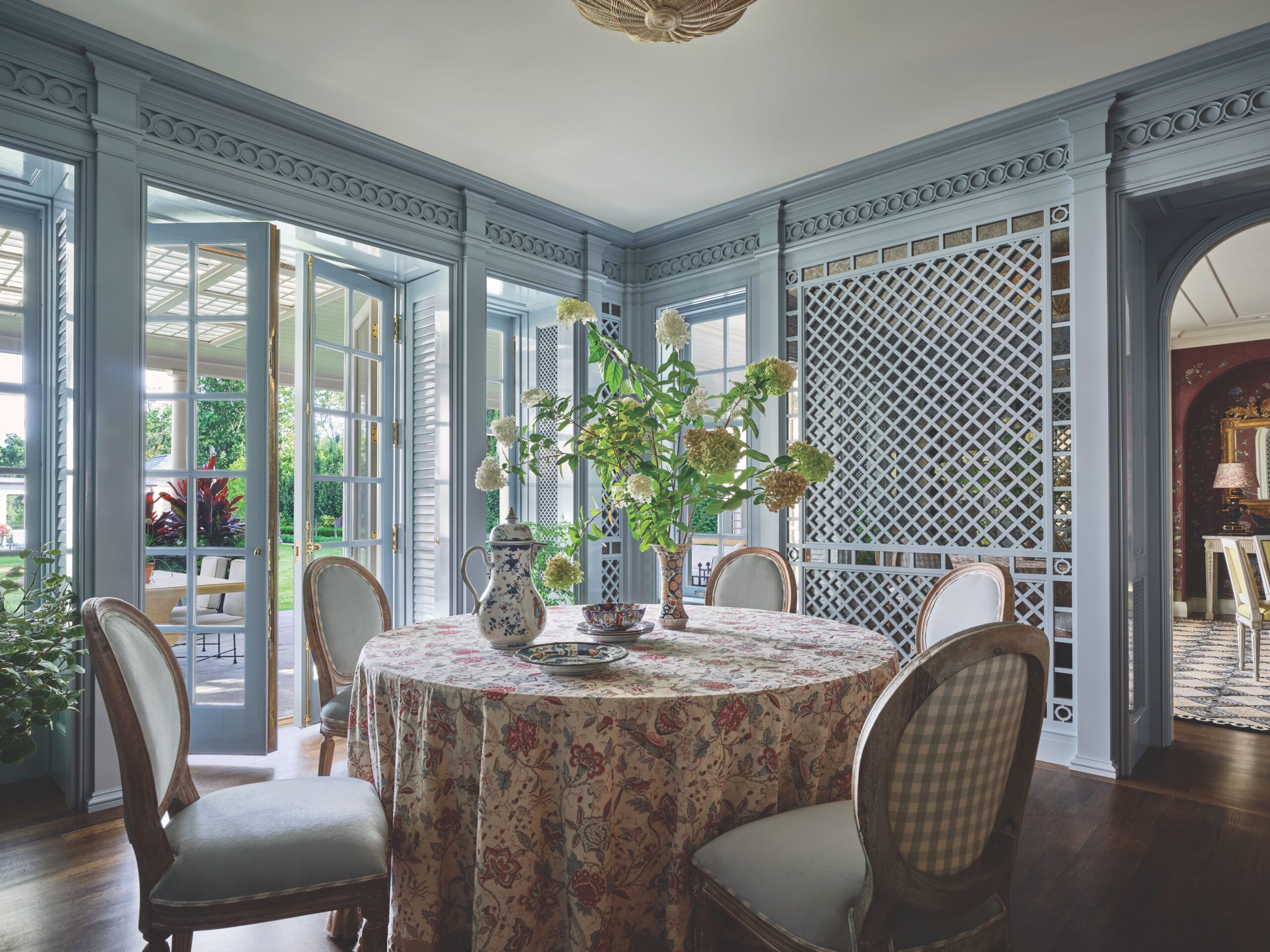 Breakfast room with lattice and round table with French chairs. Love the moody blue color.