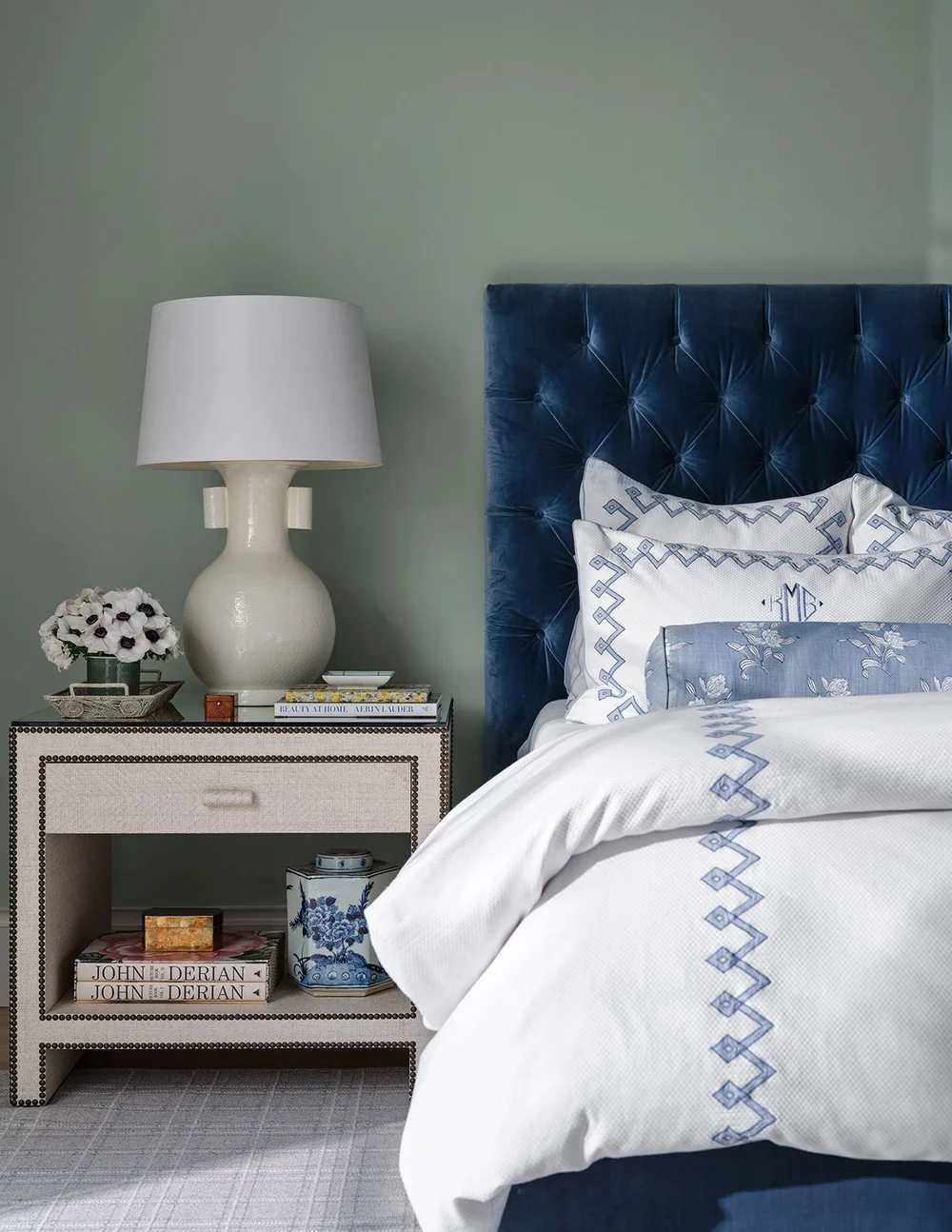Designed by Mary Beth Wagner,this place is the perfect mix of traditional touches and updated details, well-suited for family, entertaining and more. Blue and white bedroom with blue velvet tufted headboard