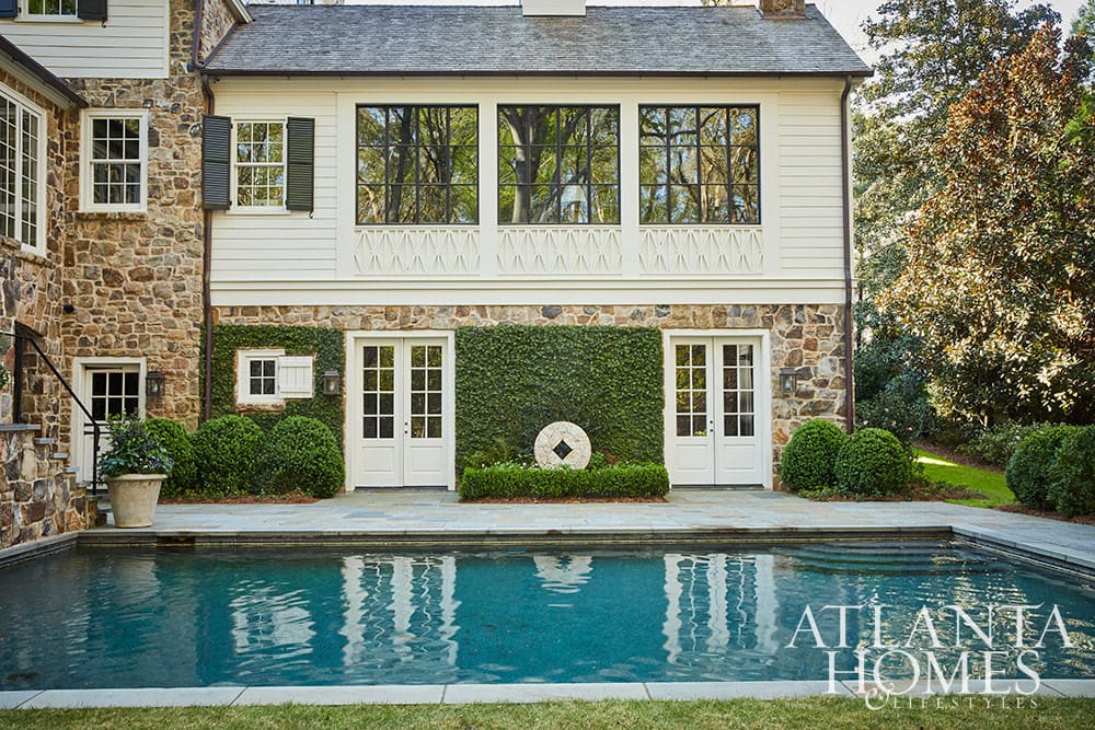 Stone Dutch Colonial home with pool in the landscaped backyard
